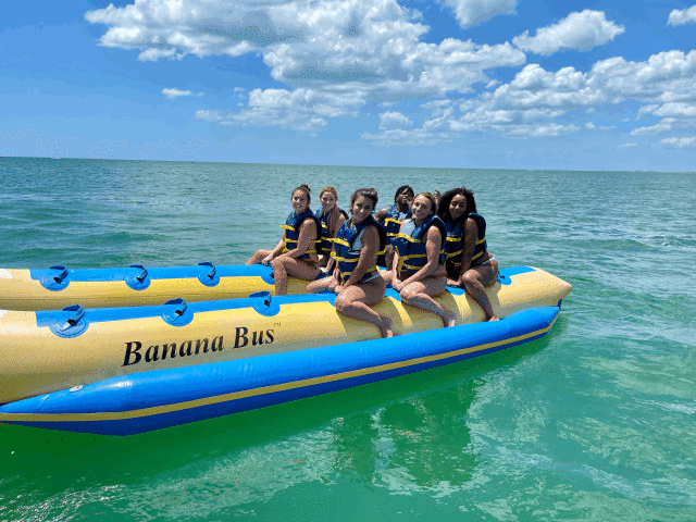 Group of tourists enjoying banana boat ride being pulled by speedboat